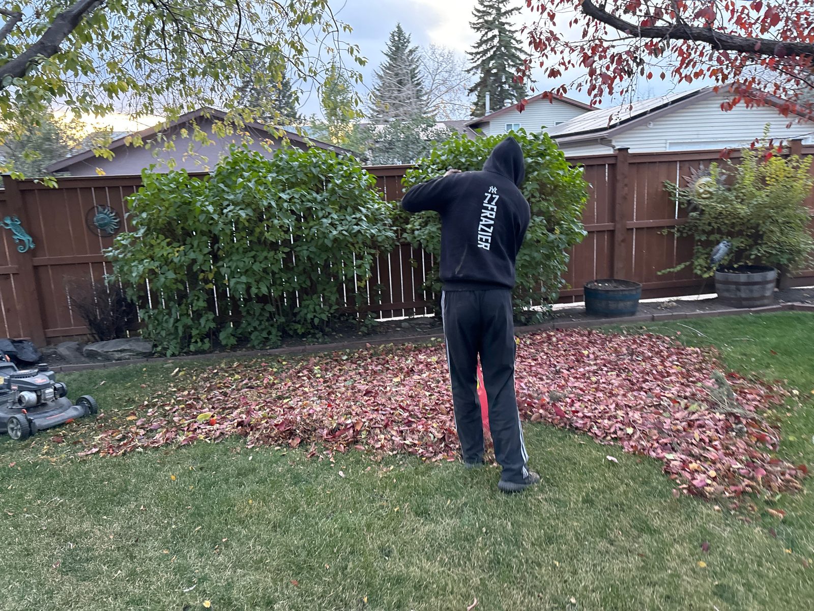 BuildScape Pros crew member bagging leaves during a seasonal yard cleanup in Calgary