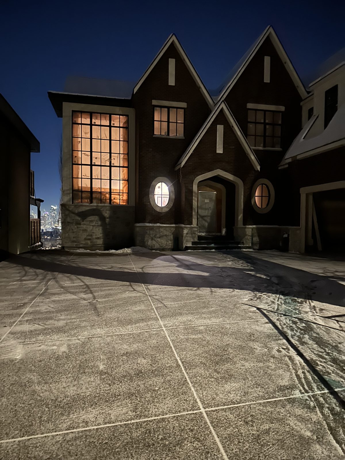 Cleared driveway at a large Calgary home at dusk after a snowfall