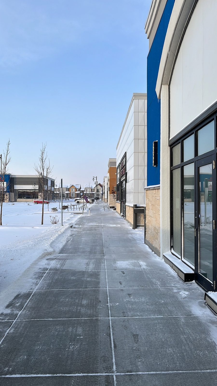 Cleared and de-iced commercial walkway outside a Calgary retail plaza in winter