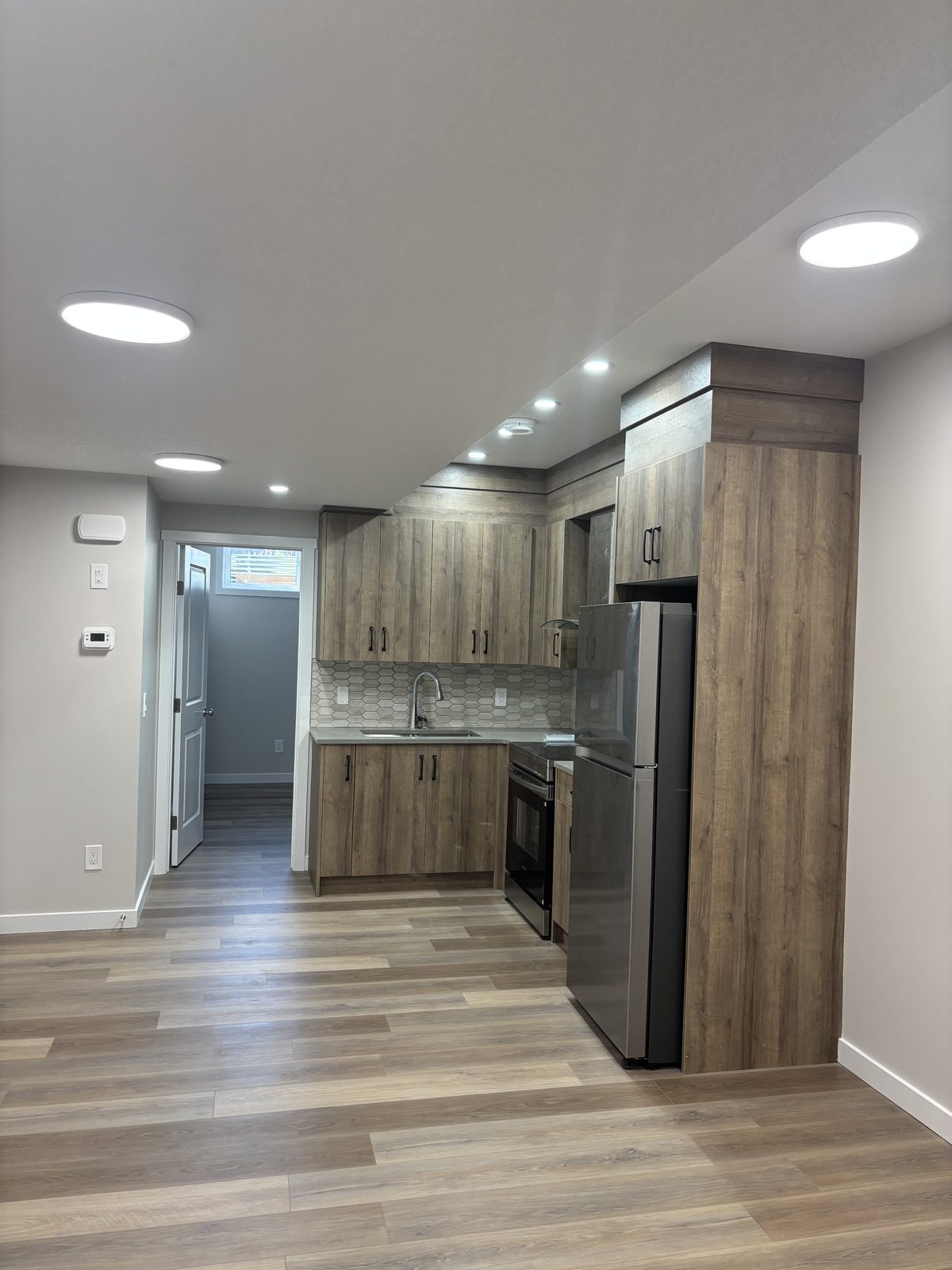 Basement suite kitchen with full-height cabinetry and stainless appliances